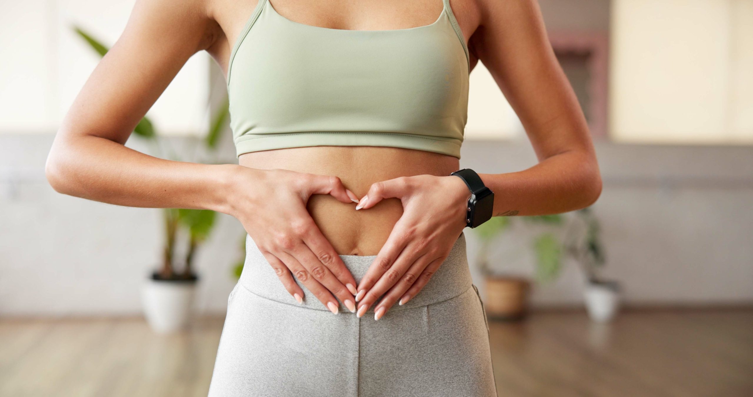 heart hands and woman in gym with belly.
