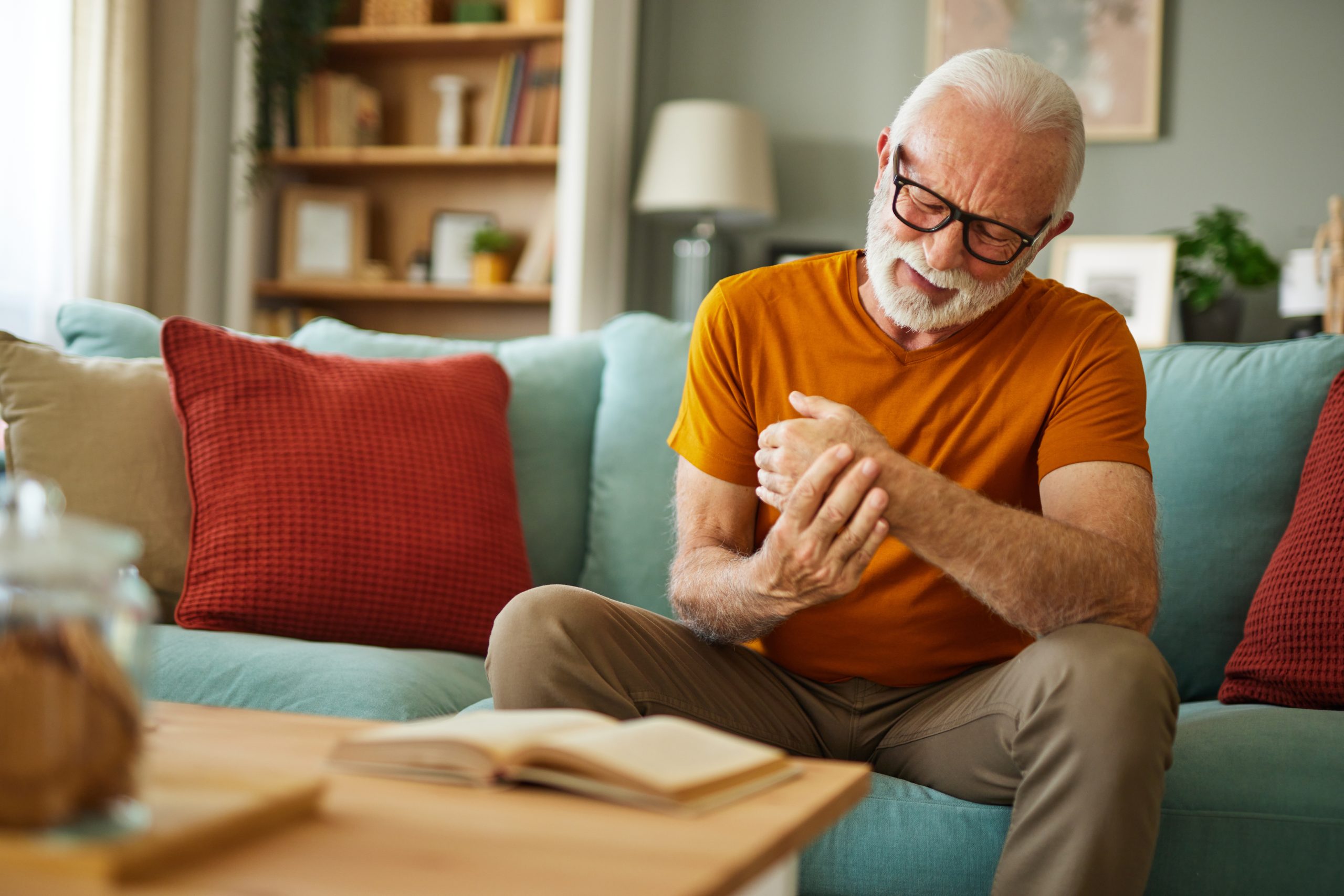 An older man examining his hand because of nerve pain.